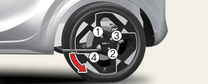Loosening a Kia Picanto wheel nut with the wheel lug nut wrench before lifting the vehicle